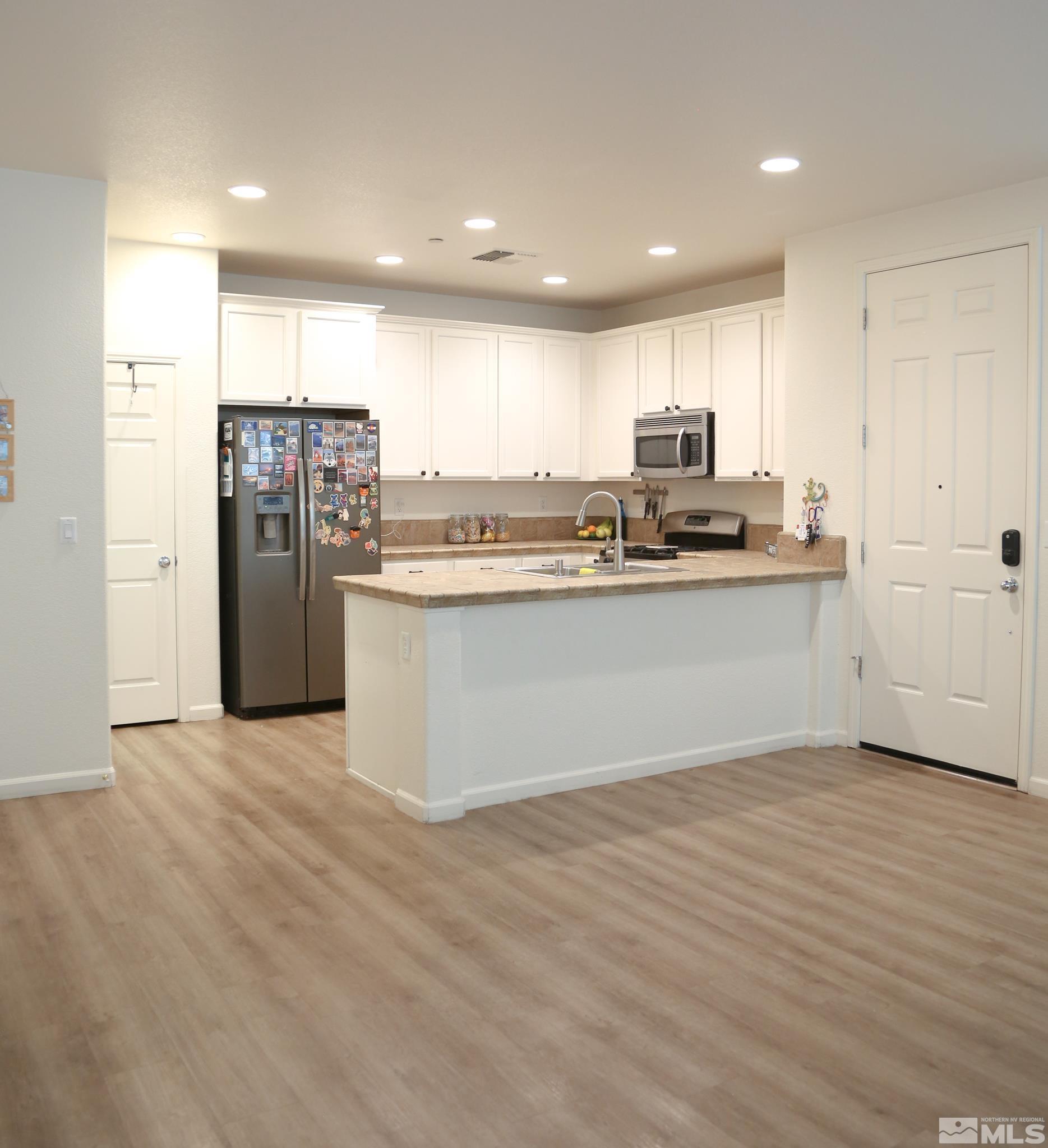 1872 Wind Ranch Road, Unit A Reno, NV 89521 - Photo 5 of 33 a kitchen with stainless steel appliances granite countertop a stove top oven a sink and a refrigerator