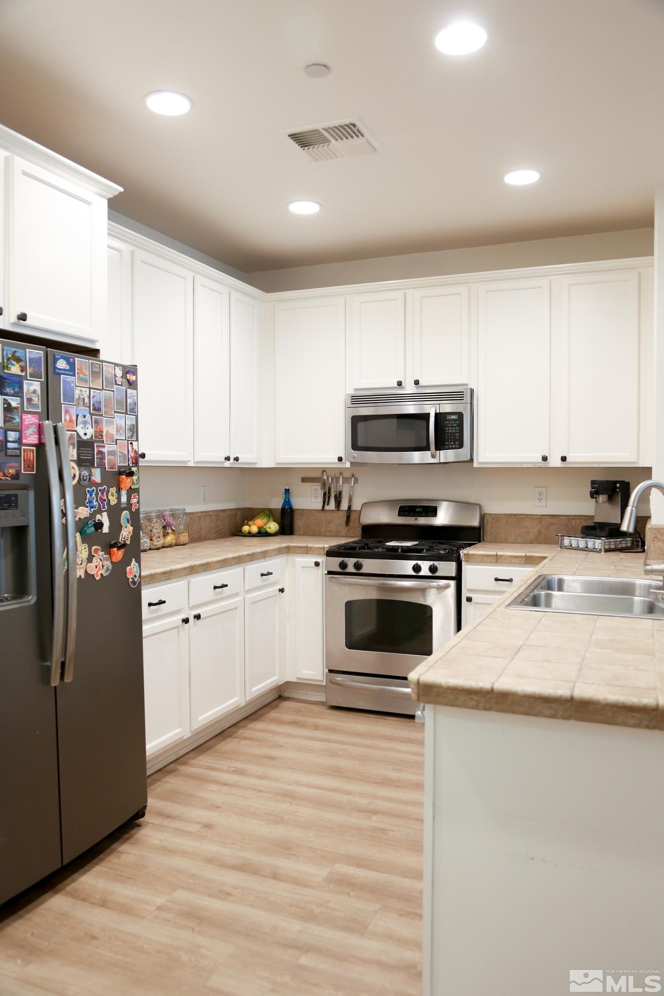 1872 Wind Ranch Road, Unit A Reno, NV 89521 - Photo 7 of 33 a kitchen with granite countertop a refrigerator stove top oven and sink