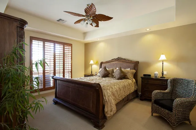 a spacious bedroom with a bed a chandelier and a couch