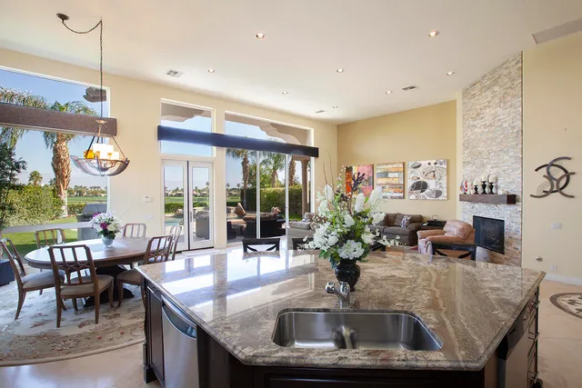 a kitchen with kitchen island granite countertop a table and chairs in it