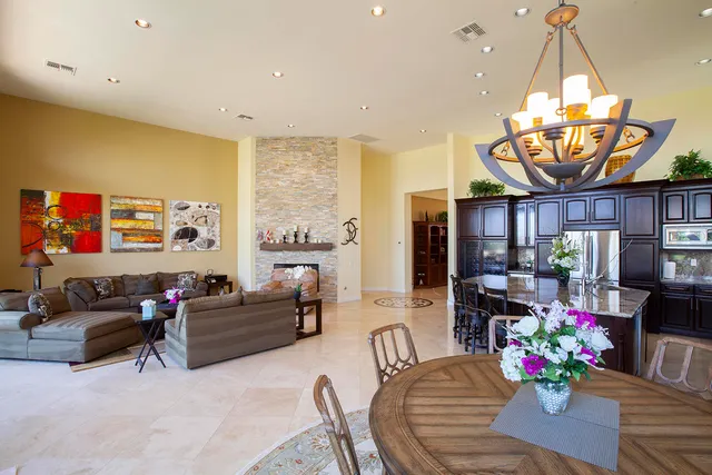 a living room with furniture a chandelier and a dining table