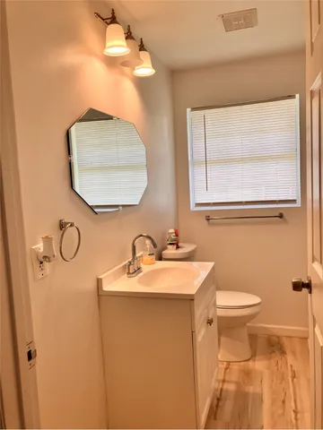 a bathroom with a toilet sink and mirror