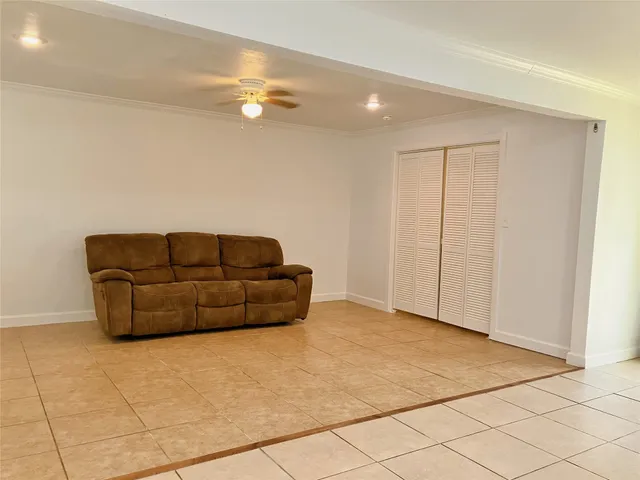 a living room with furniture and a ceiling fan