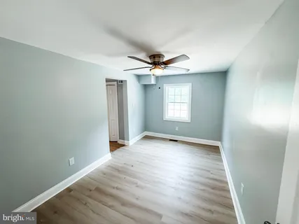an empty room with wooden floor and fireplace