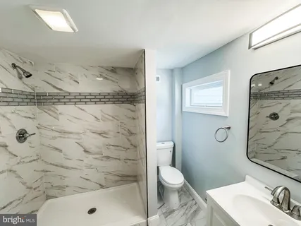 an empty room with wooden floor and a ceiling fan