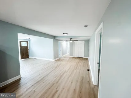 a view of an empty room with wooden floor and closet area
