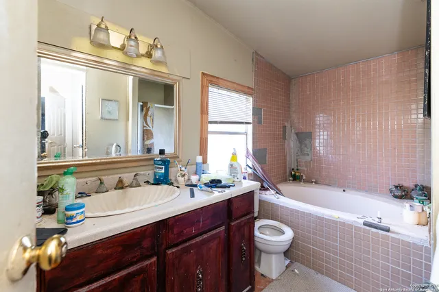a bathroom with a sink vanity mirror and toilet