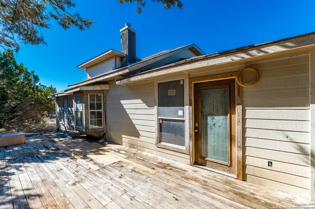 an aerial view of a house with yard and large trees