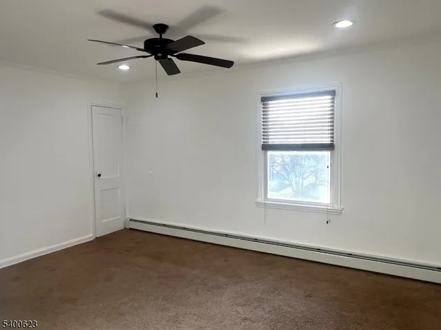 an empty room with a window and a ceiling fan