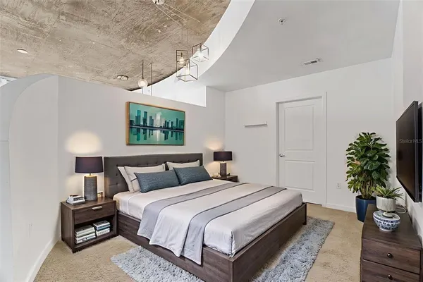 a bedroom with bed and a potted plant