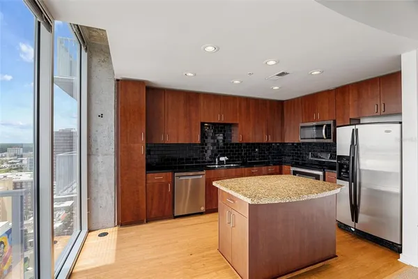 a kitchen with stainless steel appliances granite countertop a refrigerator and a sink