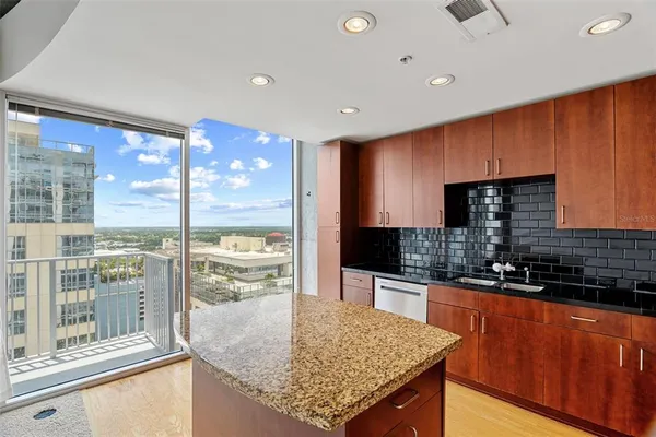 a kitchen with stainless steel appliances granite countertop sink stove and refrigerator