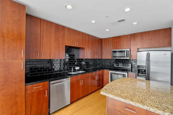 a kitchen with stainless steel appliances granite countertop a sink and stove