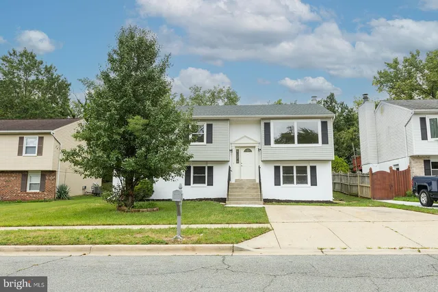 a front view of a house with a yard and trees