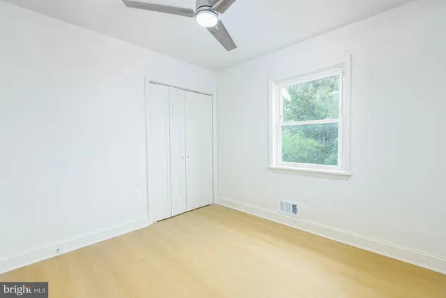 a bathroom with a granite countertop sink toilet a mirror and a window