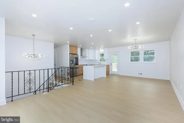 a large kitchen with stainless steel appliances kitchen island a large counter top a stove and a refrigerator