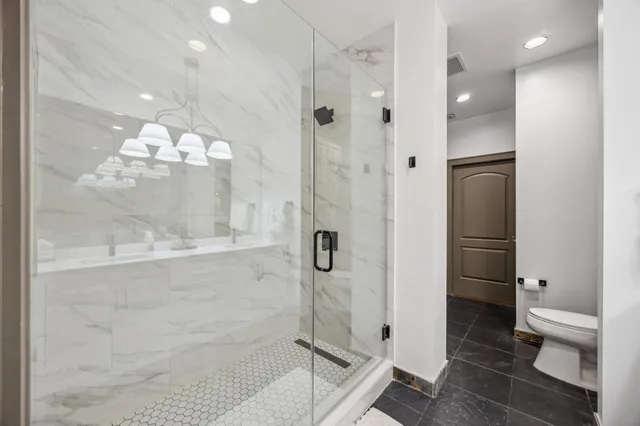 a bathroom with a glass shower door and a toilet