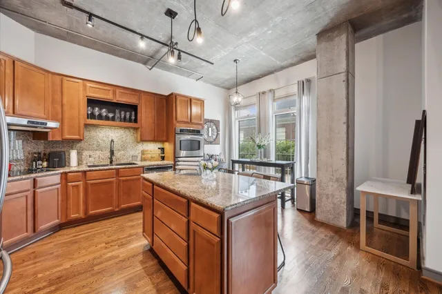 a kitchen with stainless steel appliances granite countertop a sink stove and refrigerator