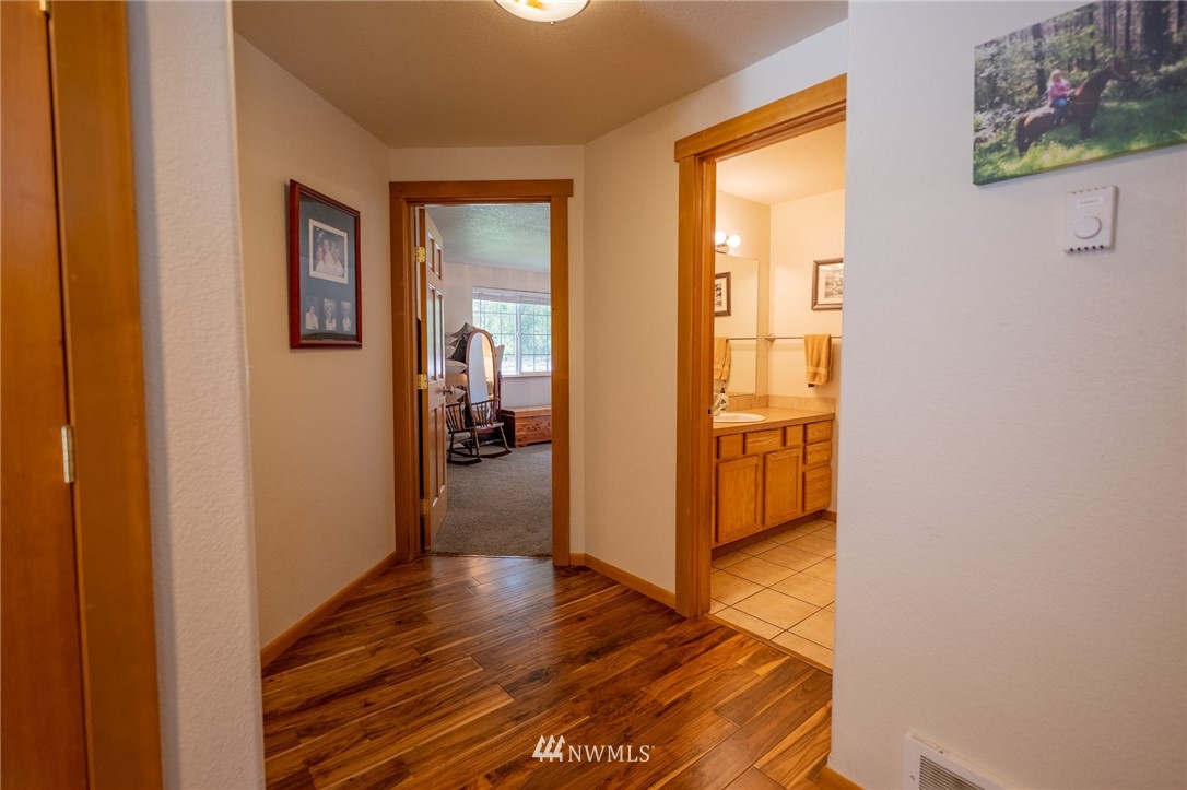 7514 191st Avenue Southwest Rochester, WA 98579 - Photo 12 of 39 a view of a hallway with wooden floor and a bathroom