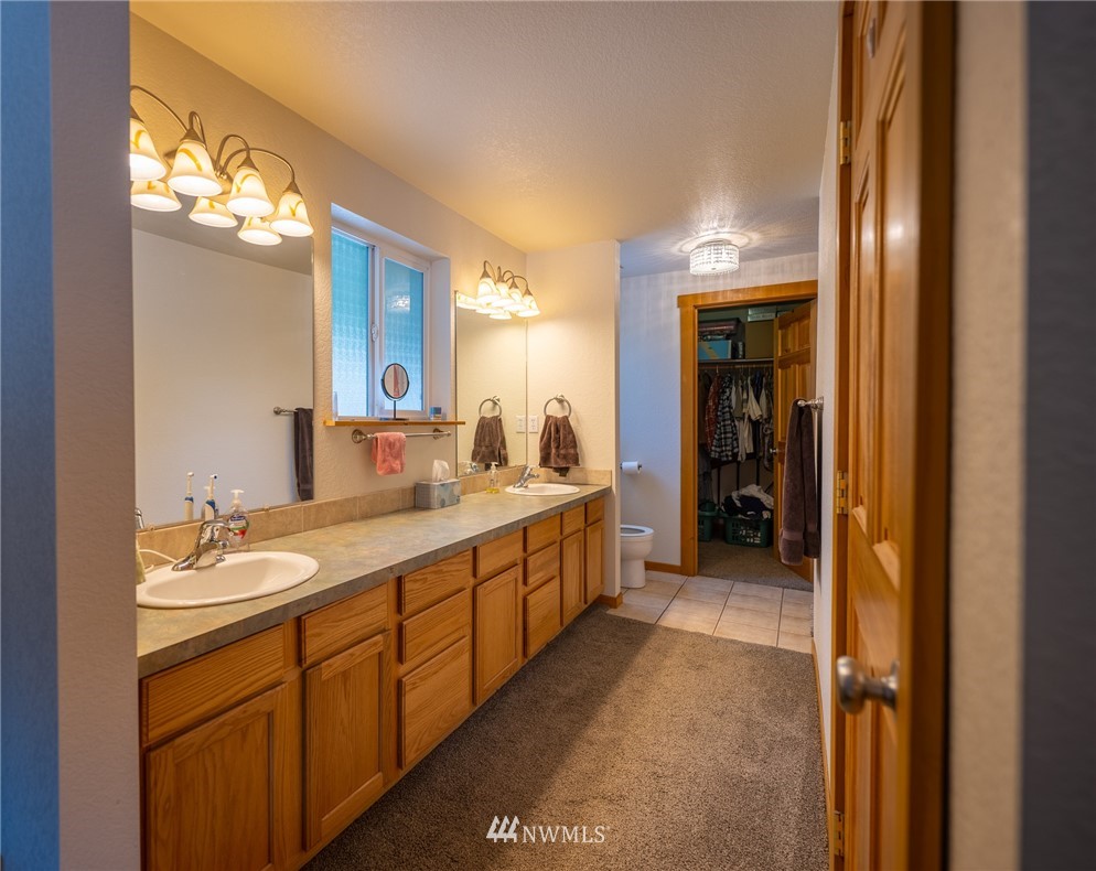 7514 191st Avenue Southwest Rochester, WA 98579 - Photo 19 of 39 a spacious bathroom with a double vanity sink and a mirror