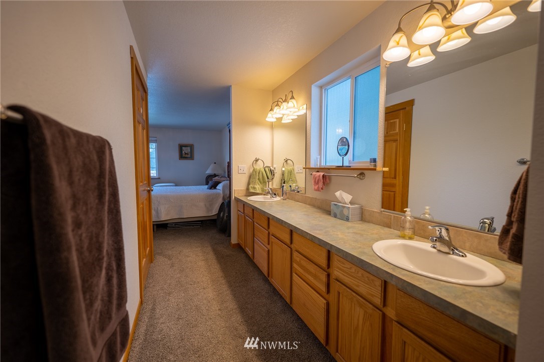 7514 191st Avenue Southwest Rochester, WA 98579 - Photo 20 of 39 a en suite bathroom with a double vanity sink and a mirror