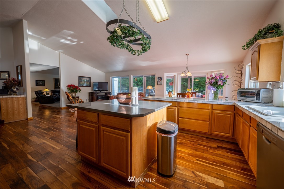 7514 191st Avenue Southwest Rochester, WA 98579 - Photo 25 of 39 a kitchen with stainless steel appliances granite countertop a sink a stove and a wooden floors