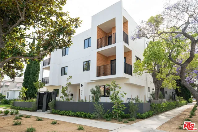 a front view of a building with trees