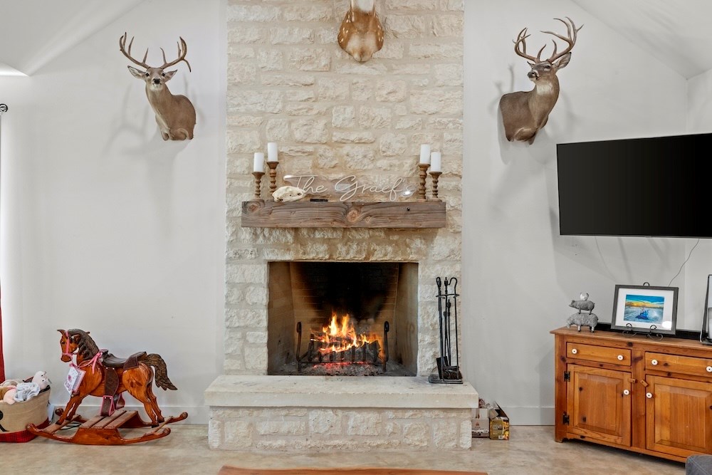1410 Grapetown Road Fredericksburg, TX 78624 - Photo 18 of 60 a living room with furniture and a fireplace