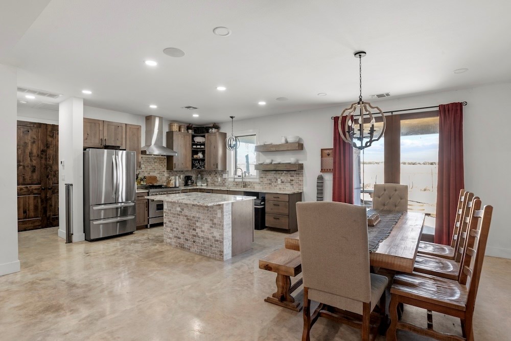 1410 Grapetown Road Fredericksburg, TX 78624 - Photo 19 of 60 a kitchen with refrigerator a sink and chairs