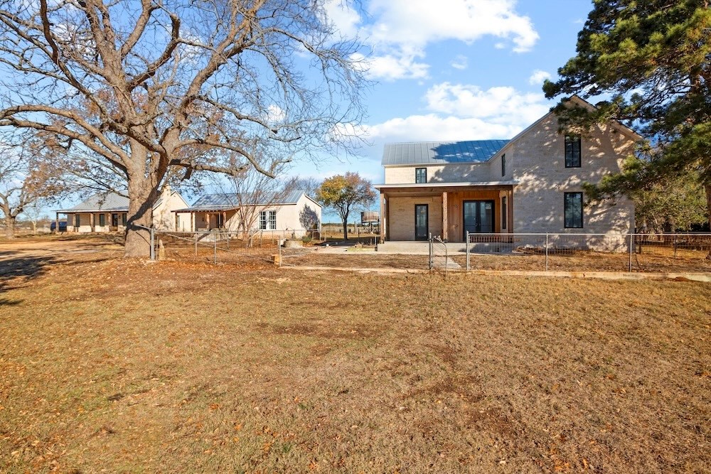 1410 Grapetown Road Fredericksburg, TX 78624 - Photo 2 of 60 a row of residential houses with yard and trees