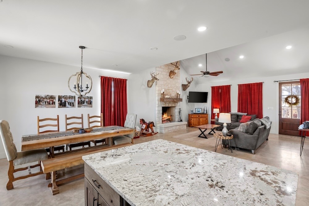 1410 Grapetown Road Fredericksburg, TX 78624 - Photo 21 of 60 a living room with furniture a fireplace and a chandelier
