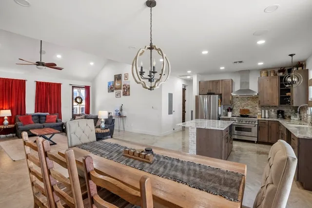 a living room with a table chairs and couches