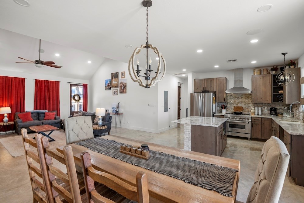 1410 Grapetown Road Fredericksburg, TX 78624 - Photo 22 of 60 a kitchen with stainless steel appliances granite countertop a stove top oven a refrigerator a sink and chairs