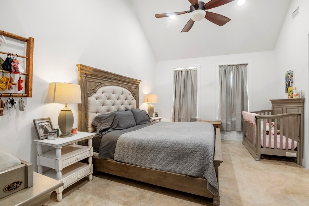 1410 Grapetown Road Fredericksburg, TX 78624 - Photo 26 of 60 a bedroom with a bed and a chandelier