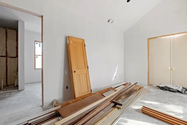 a view of a bedroom with wooden floor and windows
