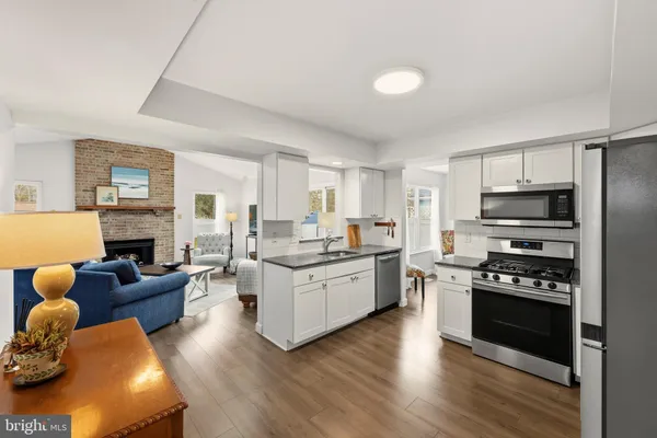 a kitchen with stainless steel appliances kitchen island granite countertop a stove and a refrigerator