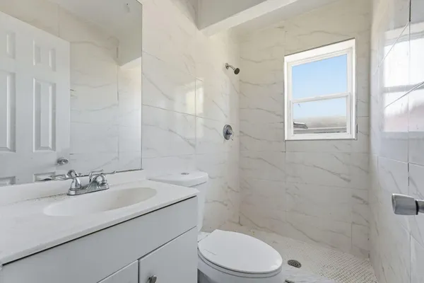 a bathroom with a sink toilet a mirror and shower