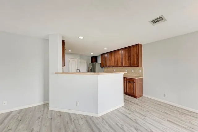 a kitchen with a refrigerator and a stove top oven