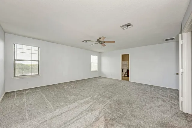 a spacious bathroom with a tub sink and mirror