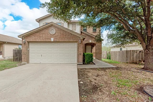 a view of a house with a yard and garage