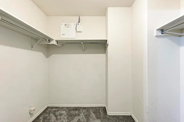 an empty room with windows and ceiling fan