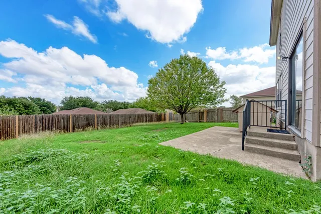 a view of a backyard with a small cabin and wooden fence