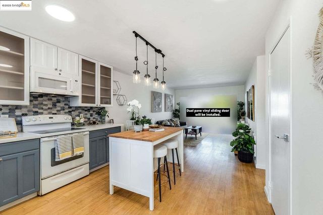 a kitchen with granite countertop a sink cabinets and stainless steel appliances