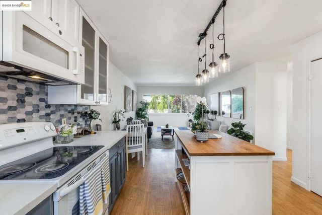 a kitchen with stainless steel appliances granite countertop a lot of counter space and wooden floor