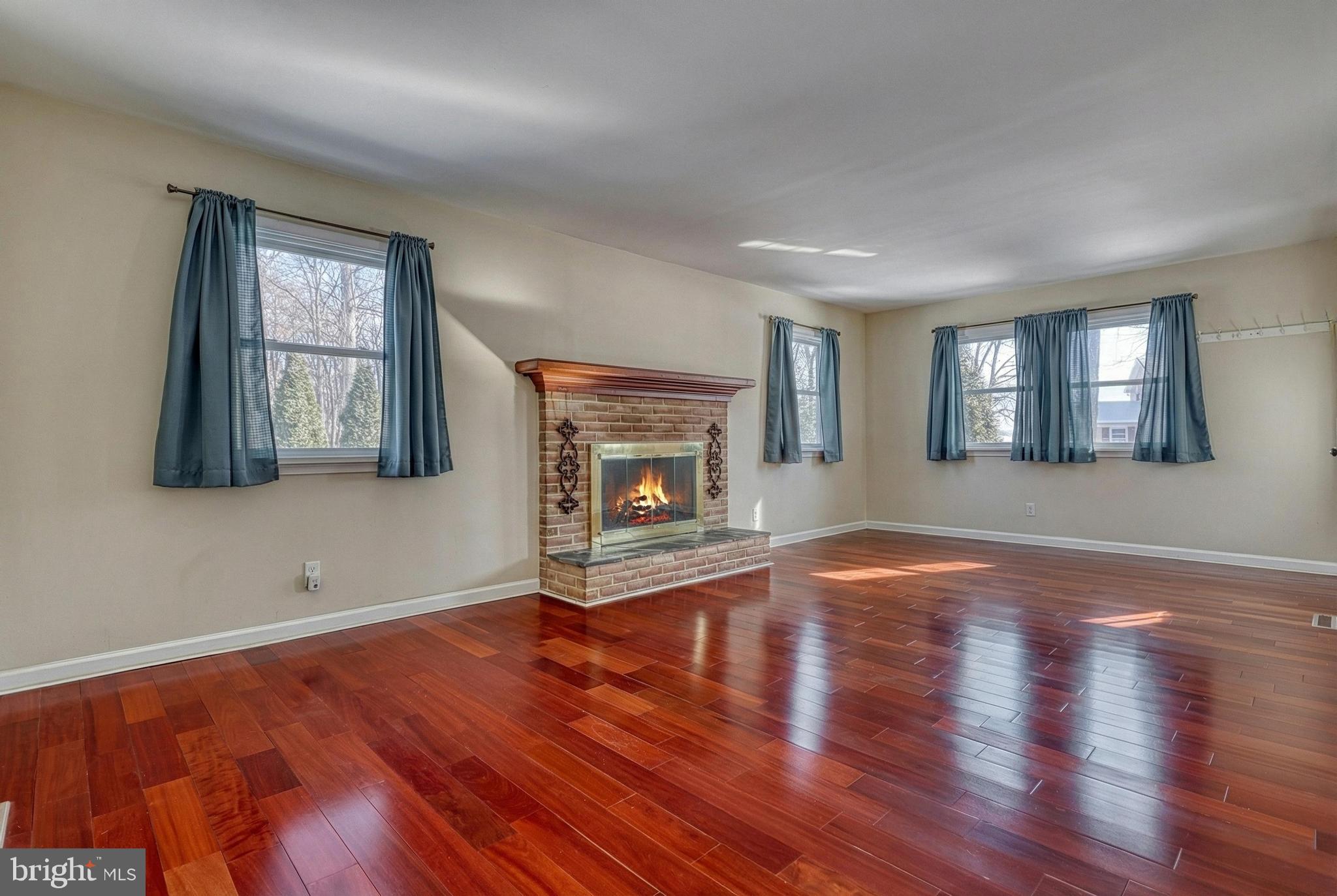 809 Flintlock Ridge Road Mechanicsburg, PA 17055 - Photo 13 of 46 an empty room with wooden floor fireplace and windows