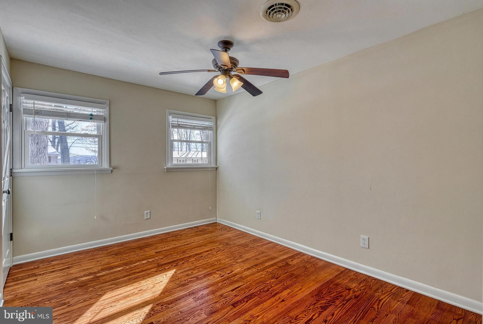 809 Flintlock Ridge Road Mechanicsburg, PA 17055 - Photo 26 of 46 an empty room with wooden floor fan and windows