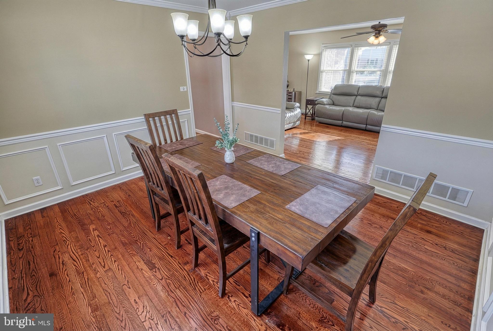 809 Flintlock Ridge Road Mechanicsburg, PA 17055 - Photo 6 of 46 a view of a dining room with furniture a chandelier and wooden floor