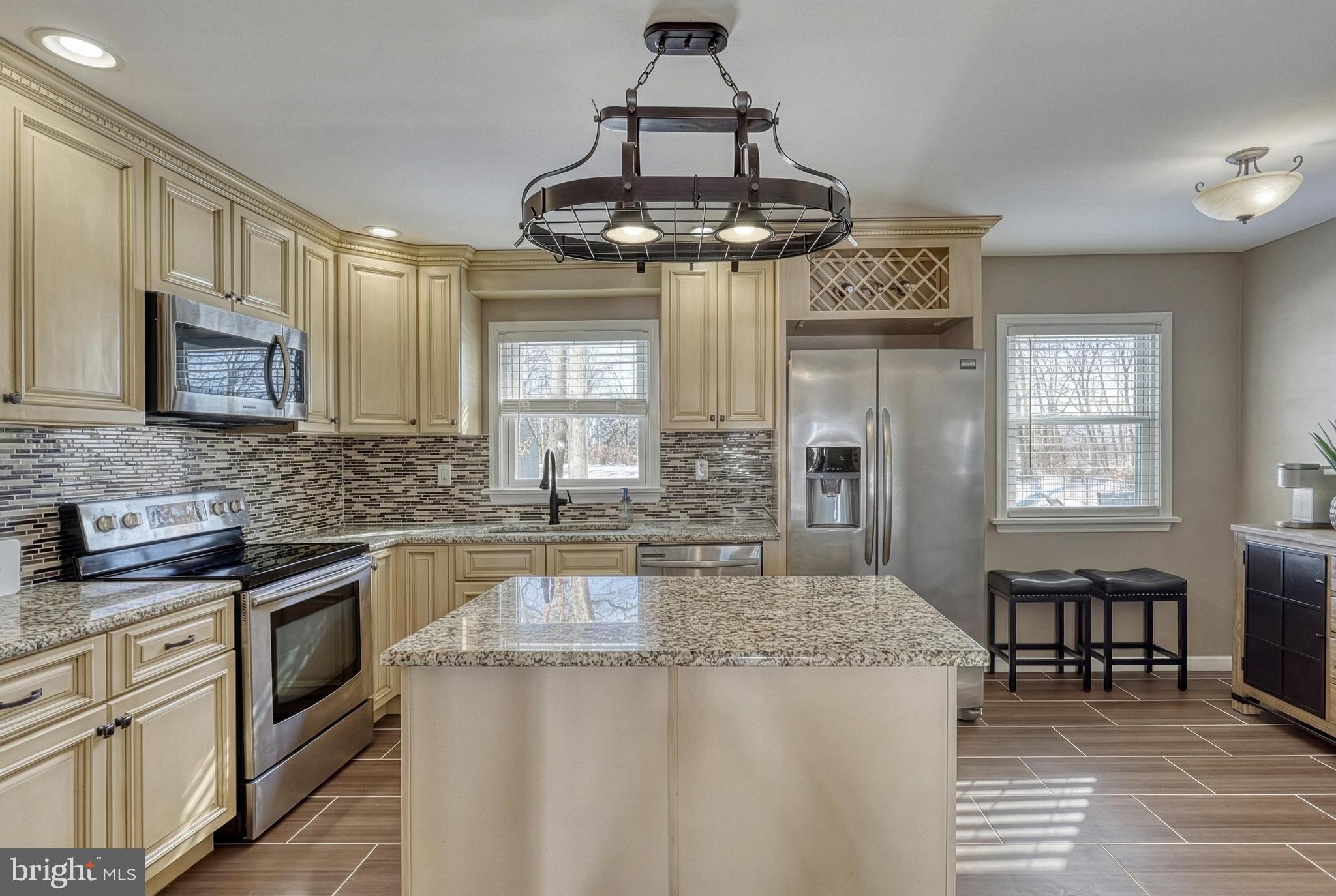 809 Flintlock Ridge Road Mechanicsburg, PA 17055 - Photo 9 of 46 a kitchen with kitchen island granite countertop stainless steel appliances a stove a sink and a refrigerator