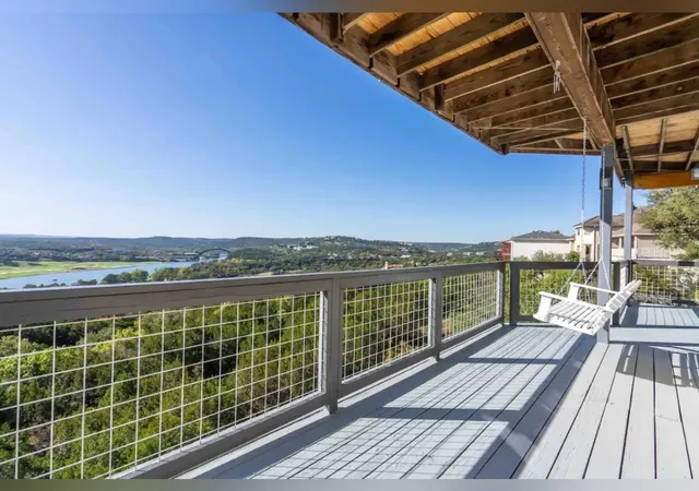 a view of a balcony with wooden floor next to a city view