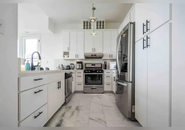 a kitchen with stainless steel appliances granite countertop a sink refrigerator and cabinets